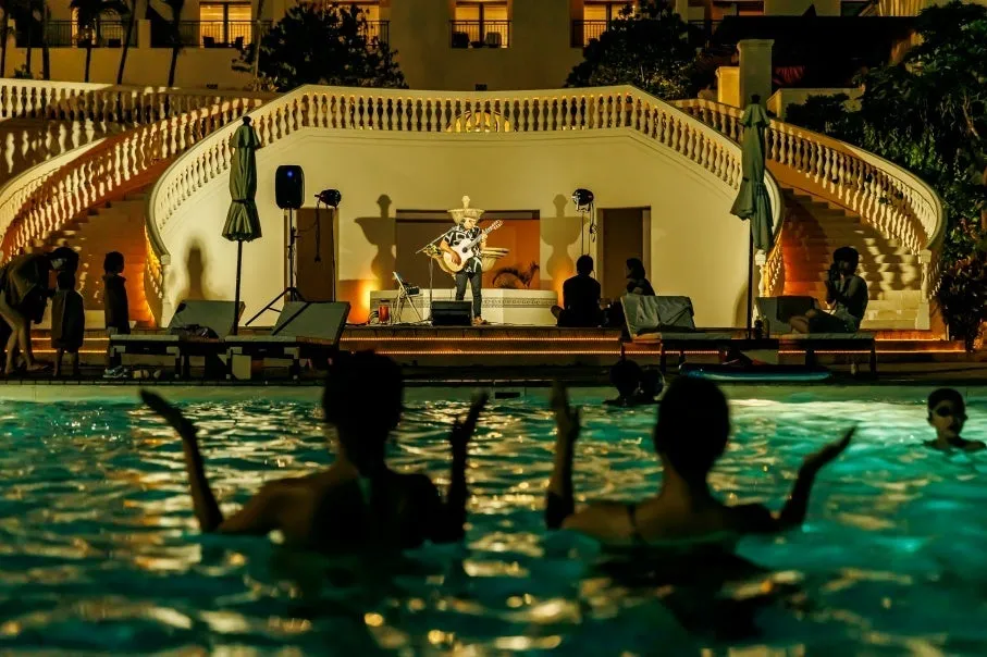 プールサイドで演奏するアーティストと楽しむ宿泊客