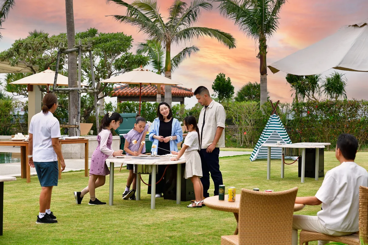 夕暮れの芝生広場でデイキャンプを楽しむ家族