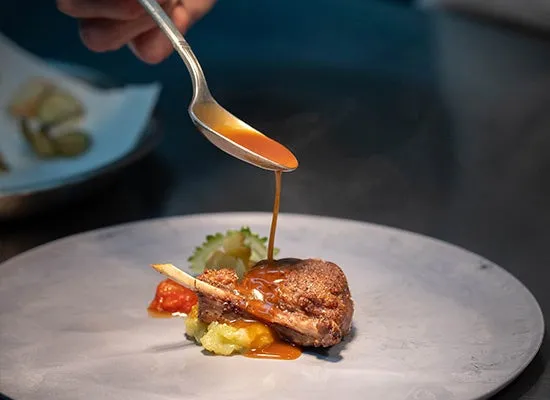 フランス料理の仕上げにソースをかける様子